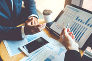 A financial presentation open on a desk with two hands in frame